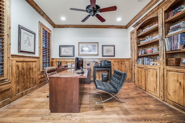home office with wainscoting, crown molding, light wood finished floors, a ceiling fan, and recessed lighting