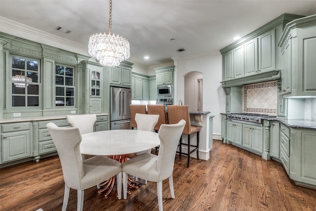 dining area with arched walkways, a chandelier, crown molding, recessed lighting, and dark wood-style floors