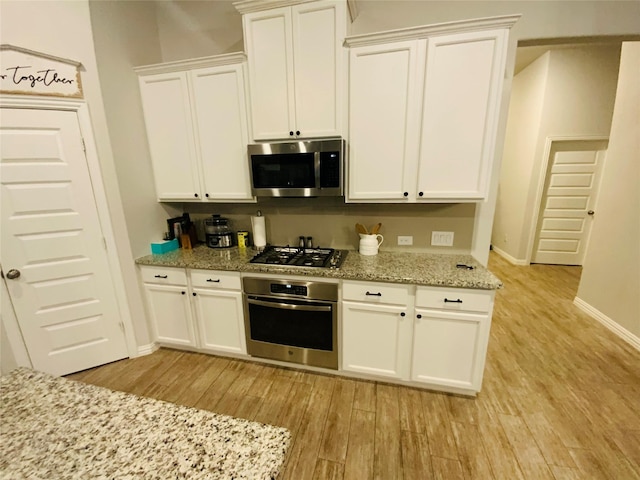 120 Black Alder Dr, Fort Worth, TX 76131 - kitchen featuring appliances with stainless steel finishes, light wood-type flooring, white cabinetry, baseboards, and light stone countertops