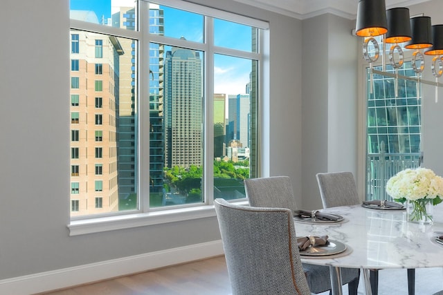 2525 N Pearl St Unit 1203, Dallas, TX 75201 - dining room featuring baseboards, wood finished floors, a chandelier, a view of city, and crown molding