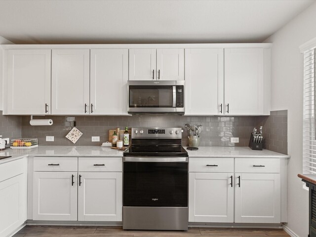 1359 Panorama Dr, Forney, TX 75126 - kitchen with stainless steel appliances, white cabinetry, backsplash, light countertops, and light wood finished floors