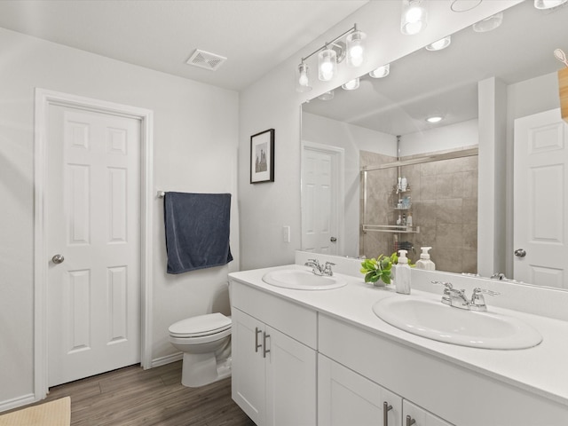 1359 Panorama Dr, Forney, TX 75126 - bathroom featuring tiled shower, wood finished floors, double vanity, and toilet