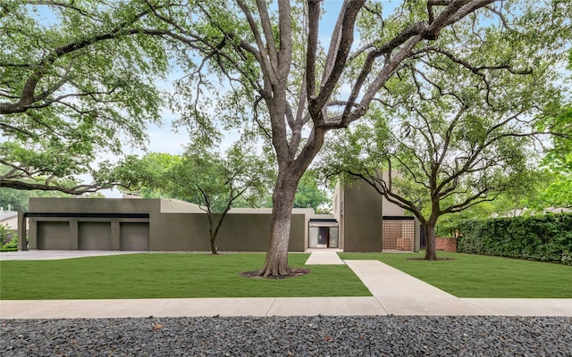 view of front of home featuring stucco siding and a front lawn