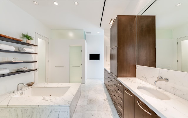 bathroom featuring vanity, recessed lighting, a whirlpool tub, and marble finish flooring
