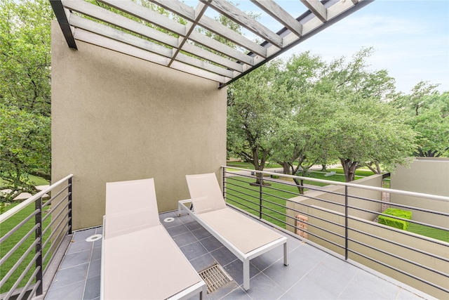view of patio featuring a pergola and a balcony