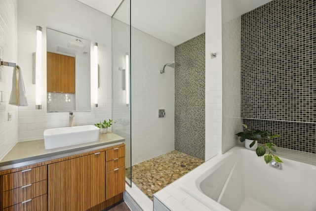 511 N Akard St Unit 1501, Dallas, TX 75201 - bathroom with tiled shower, vanity, tile walls, and a bath