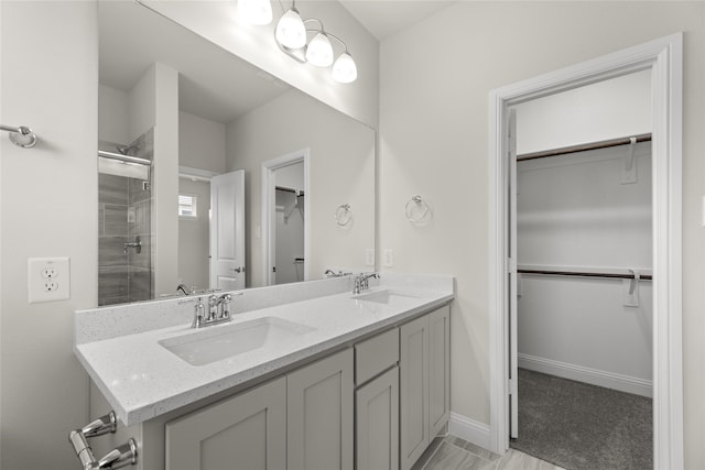219 Griffith Dr, Princeton, TX 75407 - full bathroom featuring a stall shower, double vanity, a walk in closet, and baseboards
