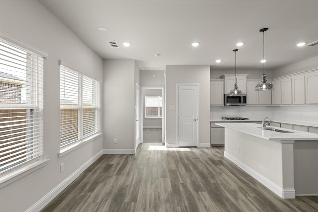 219 Griffith Dr, Princeton, TX 75407 - kitchen featuring stainless steel microwave, a sink, light countertops, wood finished floors, and recessed lighting
