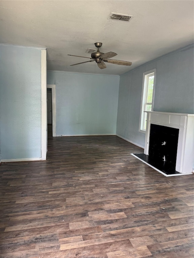 unfurnished living room featuring a ceiling fan, wood finished floors, a fireplace with raised hearth, and baseboards