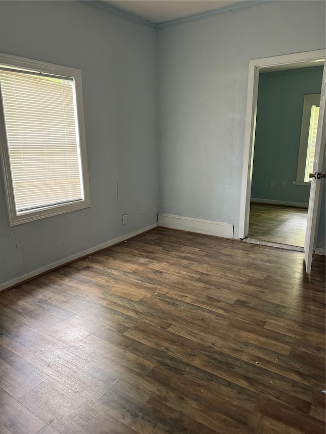 empty room featuring dark wood-style flooring and baseboards