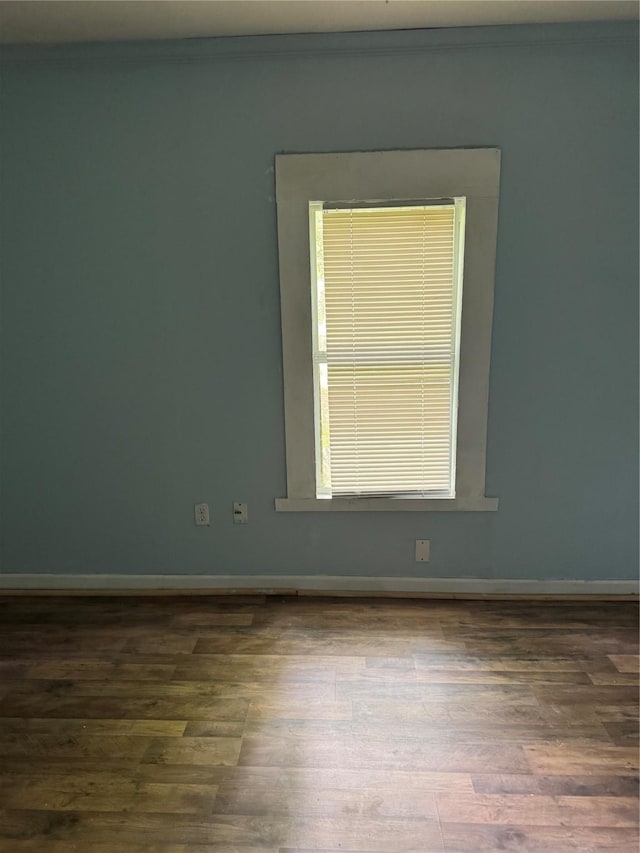 empty room featuring wood finished floors and baseboards