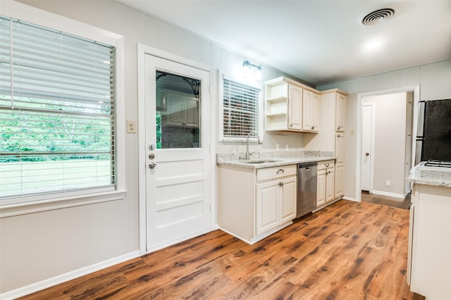 2018 Shawnee St, Denton, TX 76209 - kitchen with appliances with stainless steel finishes, a sink, wood finished floors, open shelves, and a decorative wall