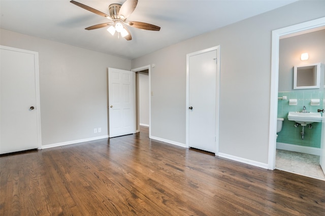 2018 Shawnee St, Denton, TX 76209 - unfurnished bedroom featuring wood finished floors, connected bathroom, baseboards, and tile walls