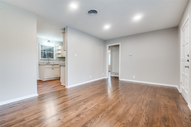2018 Shawnee St, Denton, TX 76209 - unfurnished living room featuring wood finished floors, baseboards, a sink, and recessed lighting