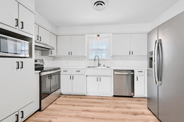 506 Melody Ln, Gainesville, TX 76240 - kitchen with stainless steel appliances, a sink, under cabinet range hood, light countertops, and backsplash