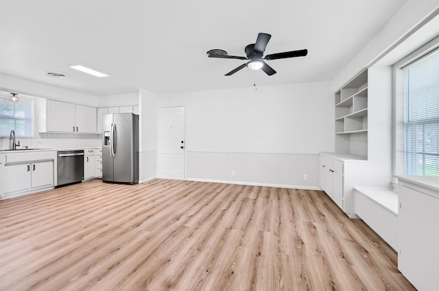 506 Melody Ln, Gainesville, TX 76240 - kitchen featuring appliances with stainless steel finishes, light wood-style flooring, a sink, and plenty of natural light