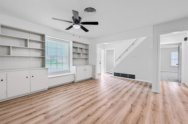 506 Melody Ln, Gainesville, TX 76240 - unfurnished living room with stairway, light wood finished floors, healthy amount of natural light, and a ceiling fan