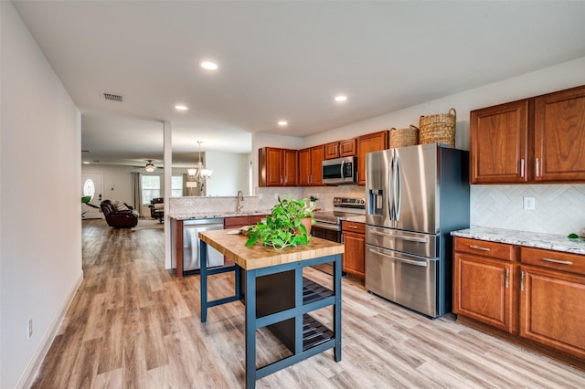 2120 Burnside Dr, Fort Worth, TX 76177 - kitchen with appliances with stainless steel finishes, a sink, decorative backsplash, light wood-style floors, and recessed lighting