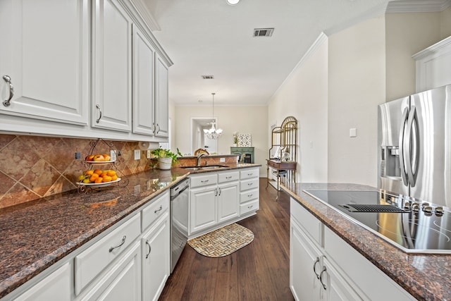 508 Wellington Rd, Coppell, TX 75019 - kitchen with appliances with stainless steel finishes, a sink, ornamental molding, backsplash, and dark wood-type flooring