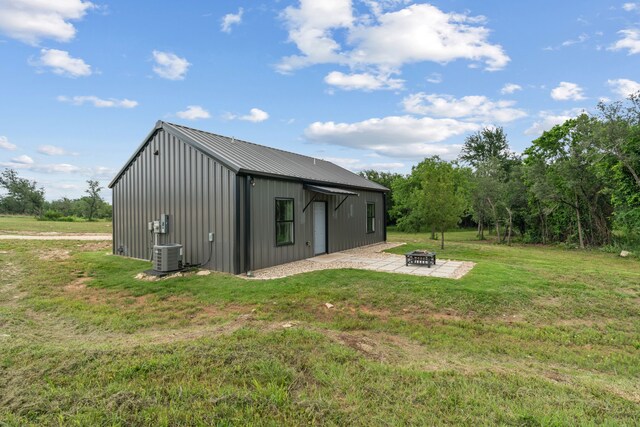 400 Round Up Ct, Stephenville, TX 76401 - back of property featuring an outdoor fire pit, a lawn, board and batten siding, metal roof, and an outbuilding