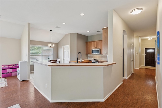 14065 Tanglebrush Trl, Fort Worth, TX 76052 - kitchen with stainless steel appliances, dark wood-style flooring, tasteful backsplash, a chandelier, and a peninsula