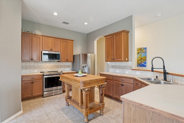 14065 Tanglebrush Trl, Fort Worth, TX 76052 - kitchen featuring stainless steel appliances, a sink, arched walkways, tasteful backsplash, and recessed lighting
