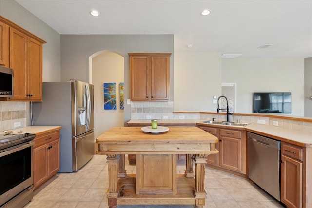 14065 Tanglebrush Trl, Fort Worth, TX 76052 - kitchen with appliances with stainless steel finishes, a sink, a peninsula, light tile patterned flooring, and recessed lighting