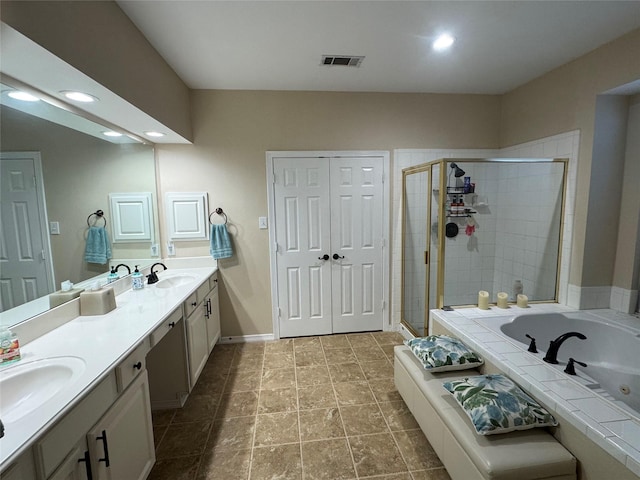 135 Freedom Ct, Rockwall, TX 75032 - bathroom featuring a jetted tub, double vanity, a shower stall, recessed lighting, and baseboards