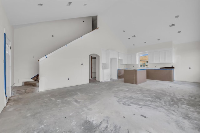 132 S Baese Rd, Elm Mott, TX 76640 - unfurnished living room with high vaulted ceiling, unfinished concrete flooring, and arched walkways