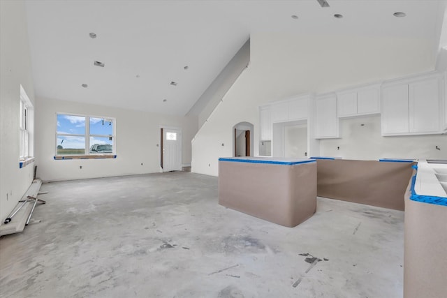 132 S Baese Rd, Elm Mott, TX 76640 - kitchen featuring high vaulted ceiling, concrete flooring, a kitchen island, white cabinets, and arched walkways
