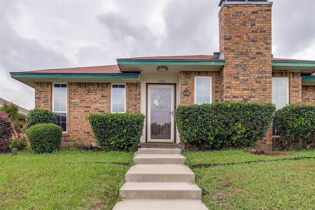 1740 Northview, Carrollton, TX 75007 - view of front of house with a front lawn, a chimney, and brick siding