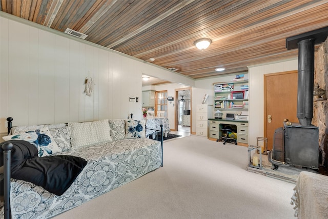 1606 S Jefferson St, Kaufman, TX 75142 - living room with a wood stove, wooden ceiling, carpet floors, and wood walls