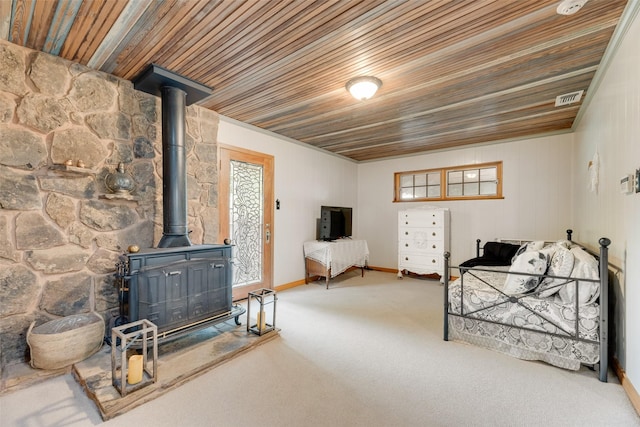 1606 S Jefferson St, Kaufman, TX 75142 - bedroom featuring a wood stove, wooden ceiling, access to outside, multiple windows, and carpet flooring