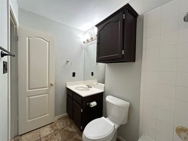 2114 Montclair Ln, Lewisville, TX 75067 - bathroom with vanity, toilet, stone finish flooring, and baseboards