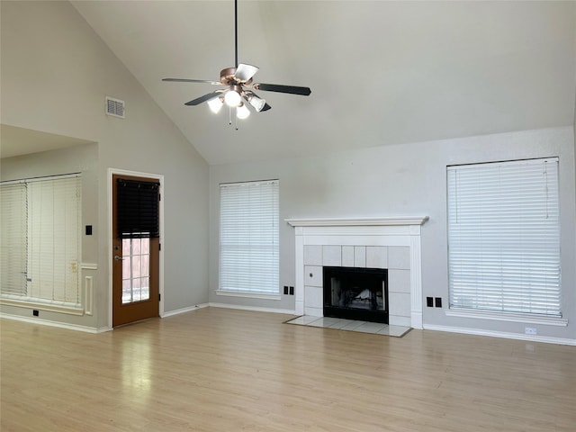 2114 Montclair Ln, Lewisville, TX 75067 - unfurnished living room with light wood-type flooring, ceiling fan, baseboards, and high vaulted ceiling