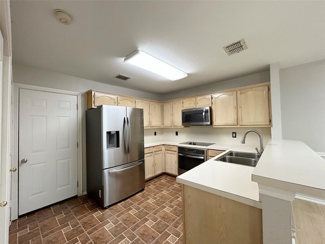 2114 Montclair Ln, Lewisville, TX 75067 - kitchen featuring stainless steel appliances, light brown cabinetry, a peninsula, and a sink