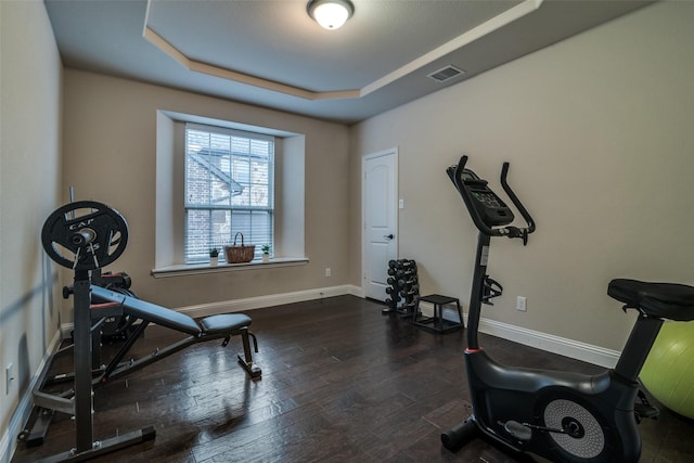 611 Southwestern Dr, Rockwall, TX 75087 - workout area with a tray ceiling, dark wood-type flooring, and baseboards