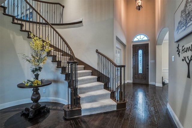 611 Southwestern Dr, Rockwall, TX 75087 - entryway featuring hardwood / wood-style flooring, stairs, a towering ceiling, arched walkways, and baseboards