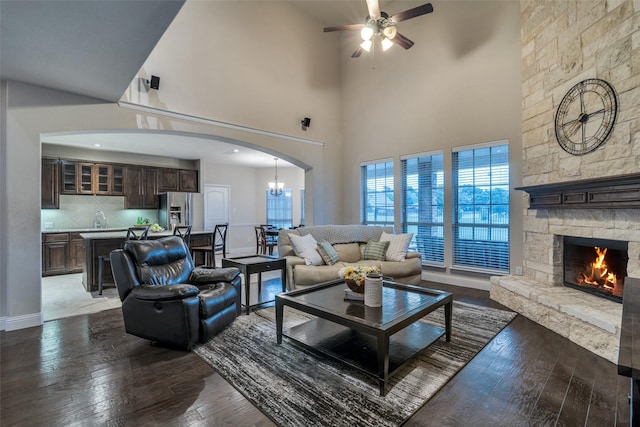 611 Southwestern Dr, Rockwall, TX 75087 - living area with a ceiling fan, wood-type flooring, a fireplace, a towering ceiling, and baseboards