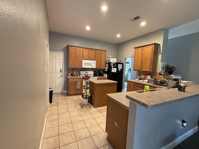 544 Bent Oak Dr, Fort Worth, TX 76131 - kitchen with white appliances, a center island, light tile patterned floors, brown cabinetry, and a peninsula