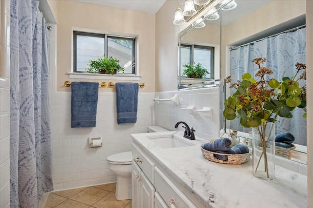 2827 Pritchett Dr, Irving, TX 75061 - bathroom with tile walls, healthy amount of natural light, tile patterned floors, vanity, and toilet