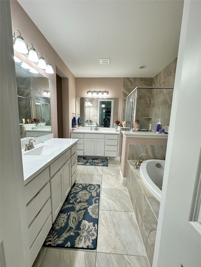 7239 Clementine Dr, Irving, TX 75063 - full bathroom featuring a stall shower, a garden tub, and two vanities