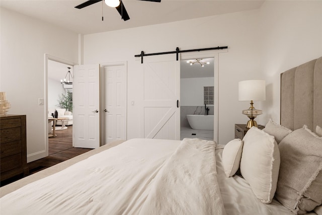 24882 US Highway 377, Whitesboro, TX 76273 - bedroom featuring a barn door, dark wood-style floors, ensuite bath, and a ceiling fan