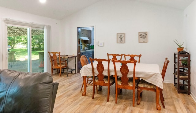 dining space with lofted ceiling, light wood finished floors, and baseboards