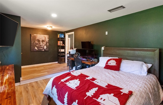 bedroom featuring wood finished floors, baseboards, and a desk