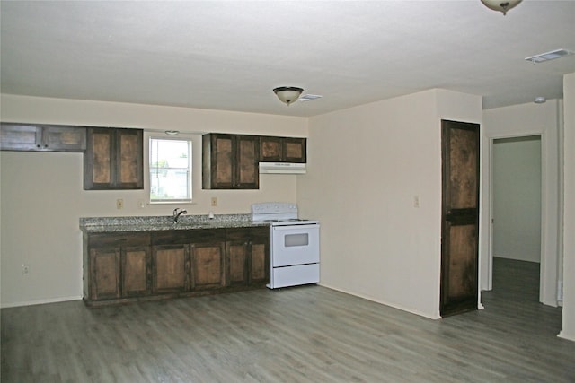 1815 Pelican W, Pelican Bay, TX 76020 - kitchen with white range with electric stovetop, under cabinet range hood, wood finished floors, and dark brown cabinets