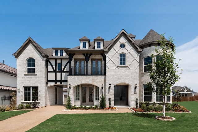 1758 Cousins Trl, Frisco, TX 75034 - view of front facade featuring a balcony, french doors, a front yard, and brick siding