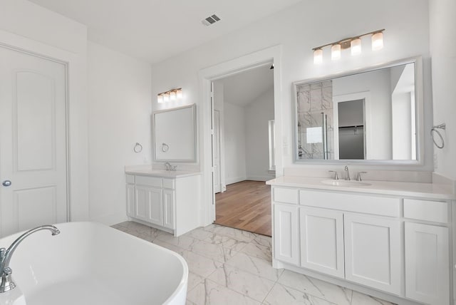 1758 Cousins Trl, Frisco, TX 75034 - bathroom featuring marble finish floors, a freestanding bath, two vanities, and baseboards