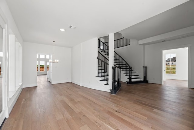 1758 Cousins Trl, Frisco, TX 75034 - unfurnished living room featuring a chandelier, light wood-style floors, healthy amount of natural light, stairway, and recessed lighting