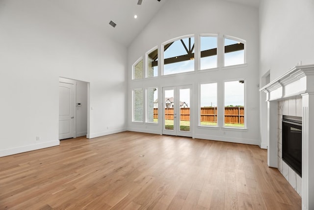 1758 Cousins Trl, Frisco, TX 75034 - unfurnished living room featuring high vaulted ceiling, a tile fireplace, light wood finished floors, healthy amount of natural light, and a ceiling fan